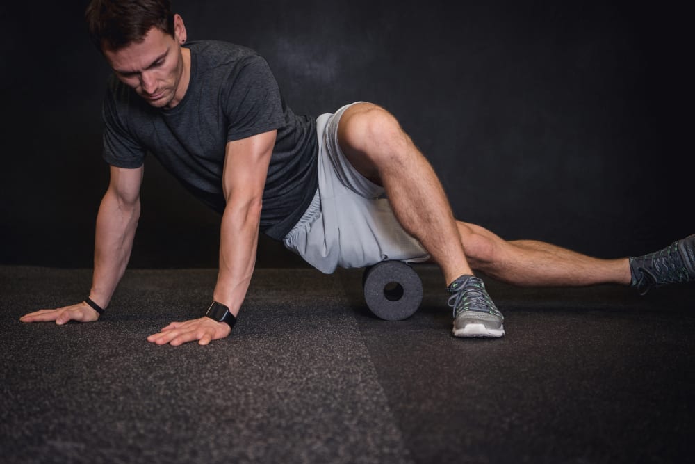 man using a foam roller for mobility warmup