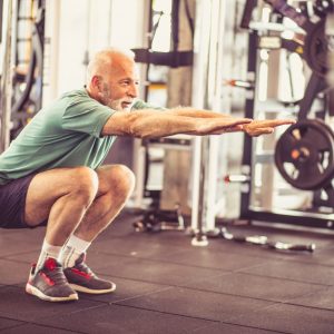 man squatting with arms out in front of him