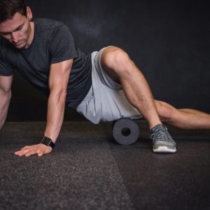 man using a foam roller for mobility warmup